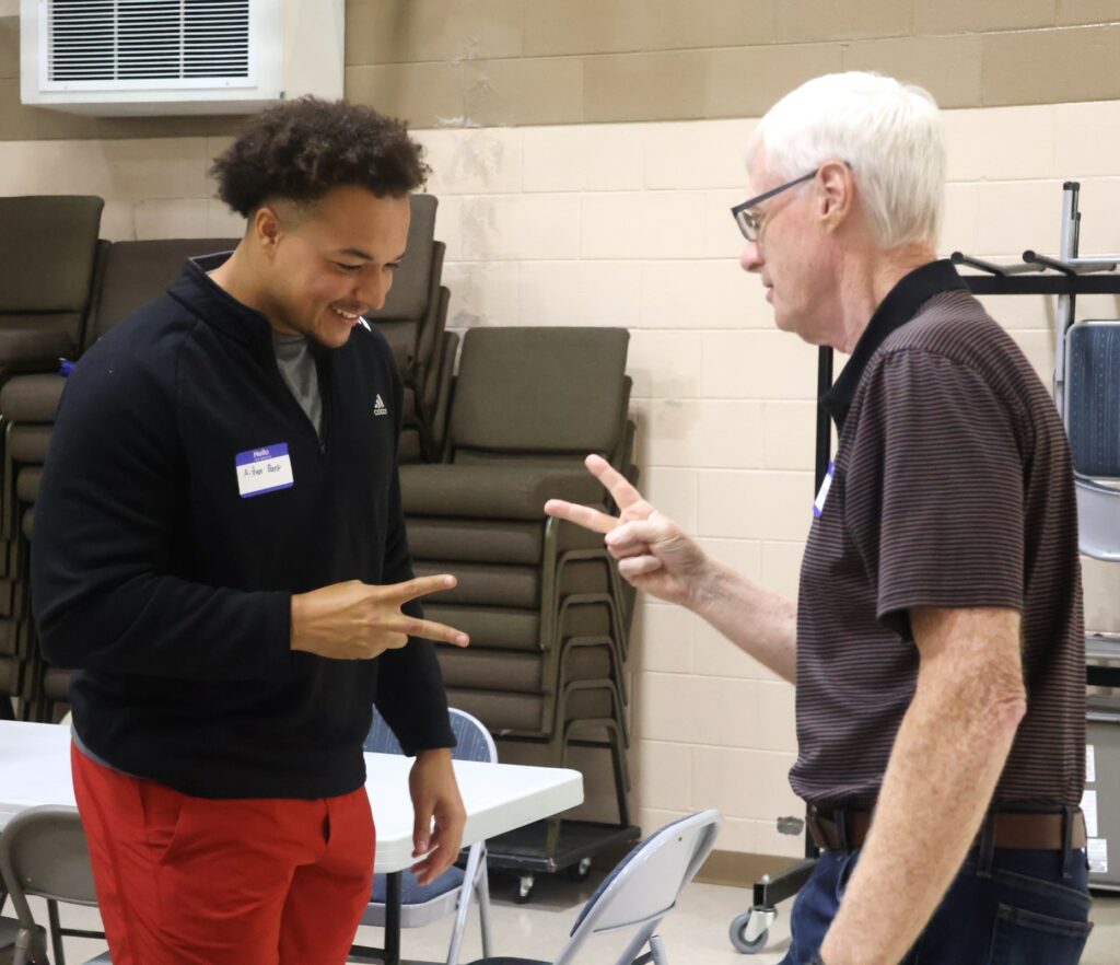 Student Aidan Dark, left, and Dr. David Smith, retired pastor of Tusculum Baptist Church, play a game of rock, paper, scissors at SPOT