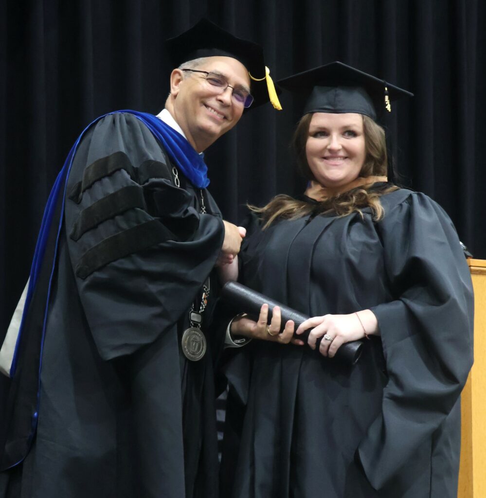 Dr. Hummel, left, congratulates a graduate.