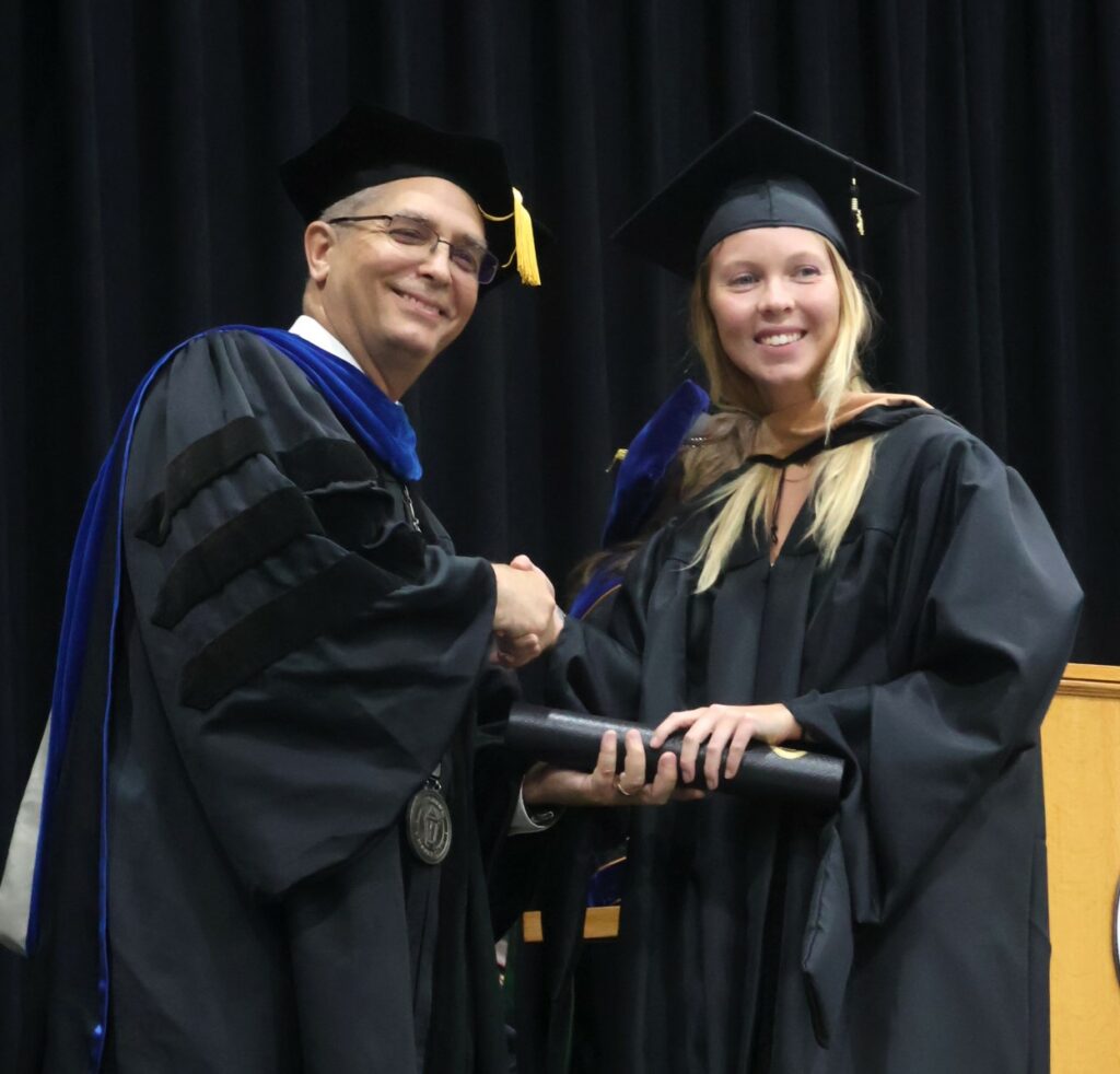 Dr. Hummel, left, congratulates a graduate.