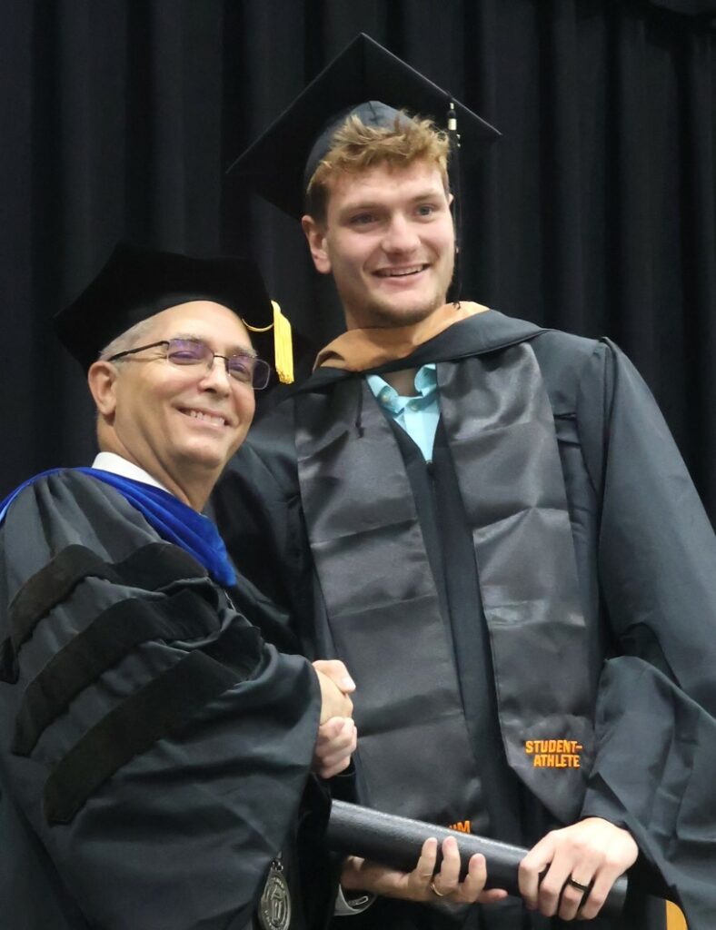 Dr. Hummel, left, congratulates a graduate.