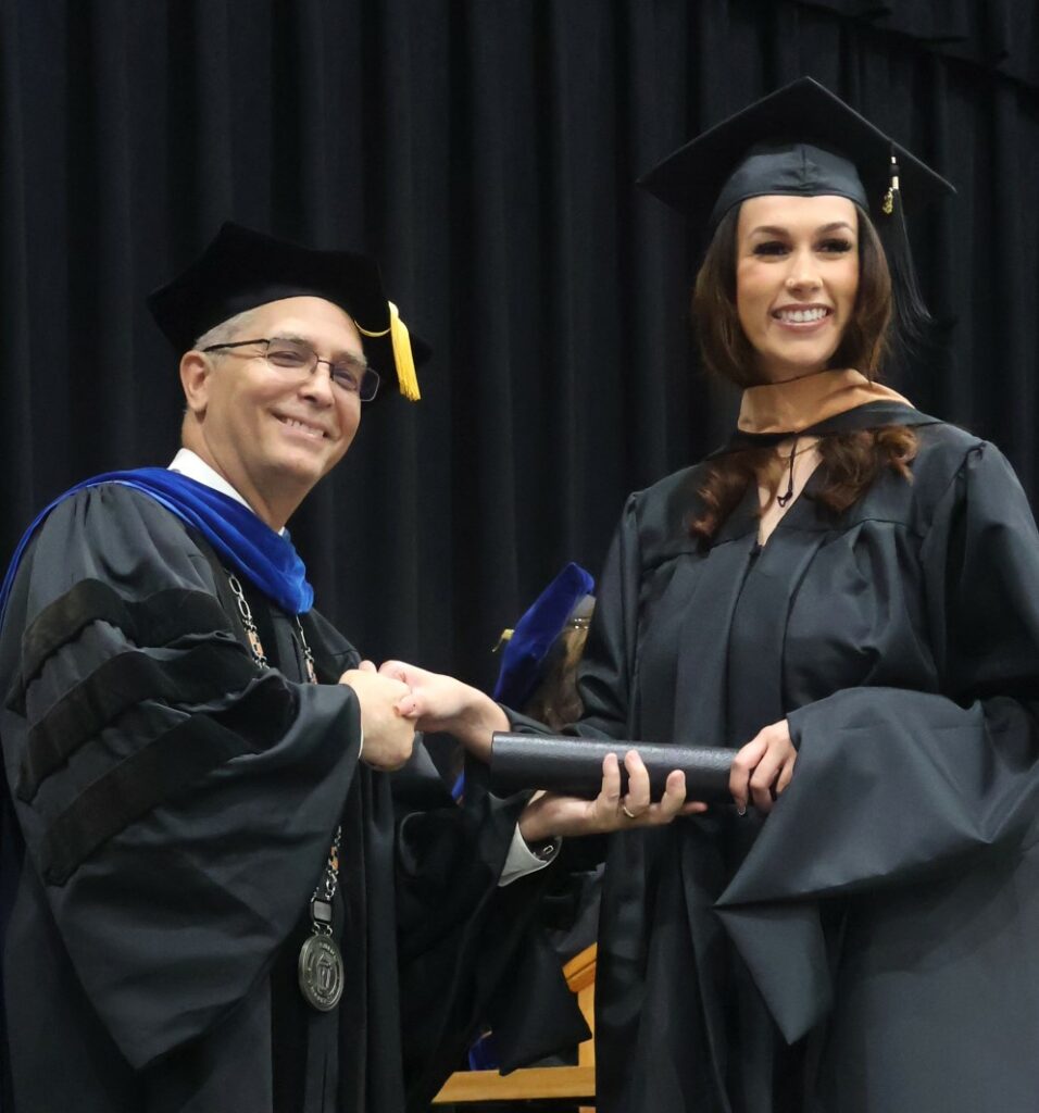 Dr. Hummel, left, congratulates a graduate.