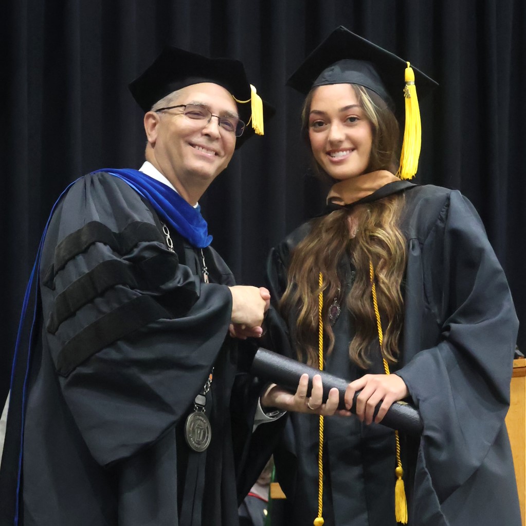 Dr. Hummel, left, congratulates a graduate.