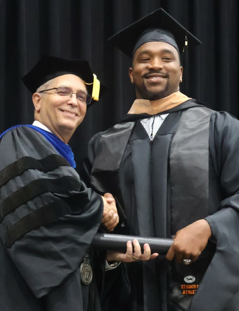 Dr. Hummel, left, congratulates a graduate.