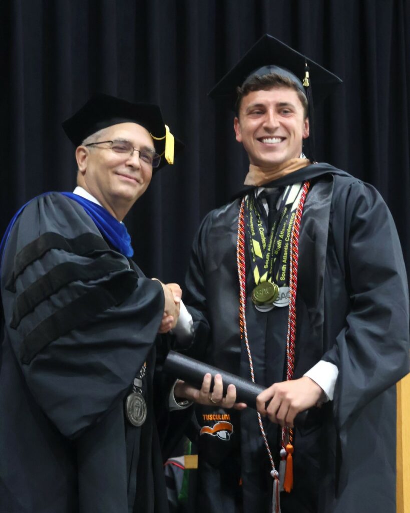 Dr. Hummel, left, congratulates a graduate.