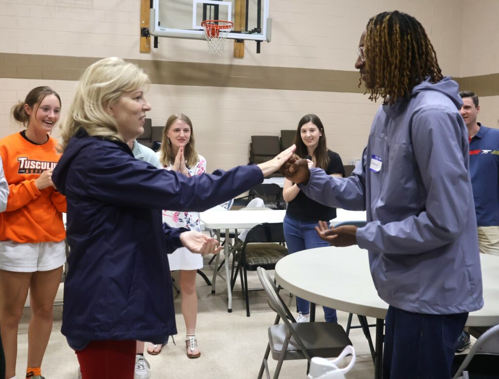 Betty Smith, left, and a student play rock, paper, scissors at SPOT.