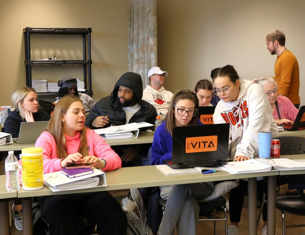 Student Angela Sanchez, right, helps instruct fellow Pioneers in the VITA training class.