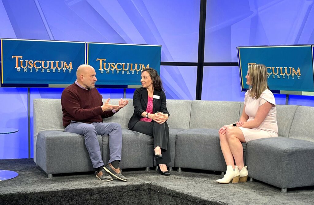 Bill Bledsoe, left, speaks about the Valentine's Painting Night, while Rouja Green, center, and Kelly Grosfield, the interviewer, listen.