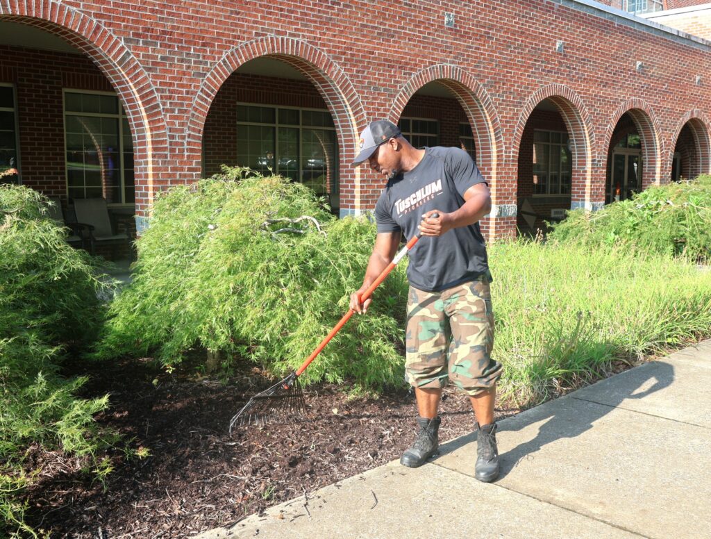 An employee performs landscaping.