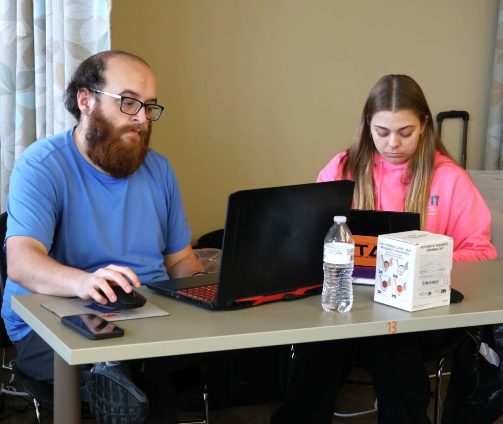 Alumnus Dakota Hammonds, left, assists a student in the VITA training class.