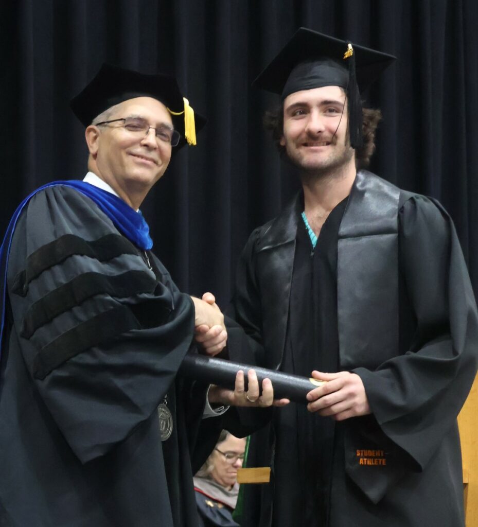 Dr. Hummel, left, congratulates a graduate.