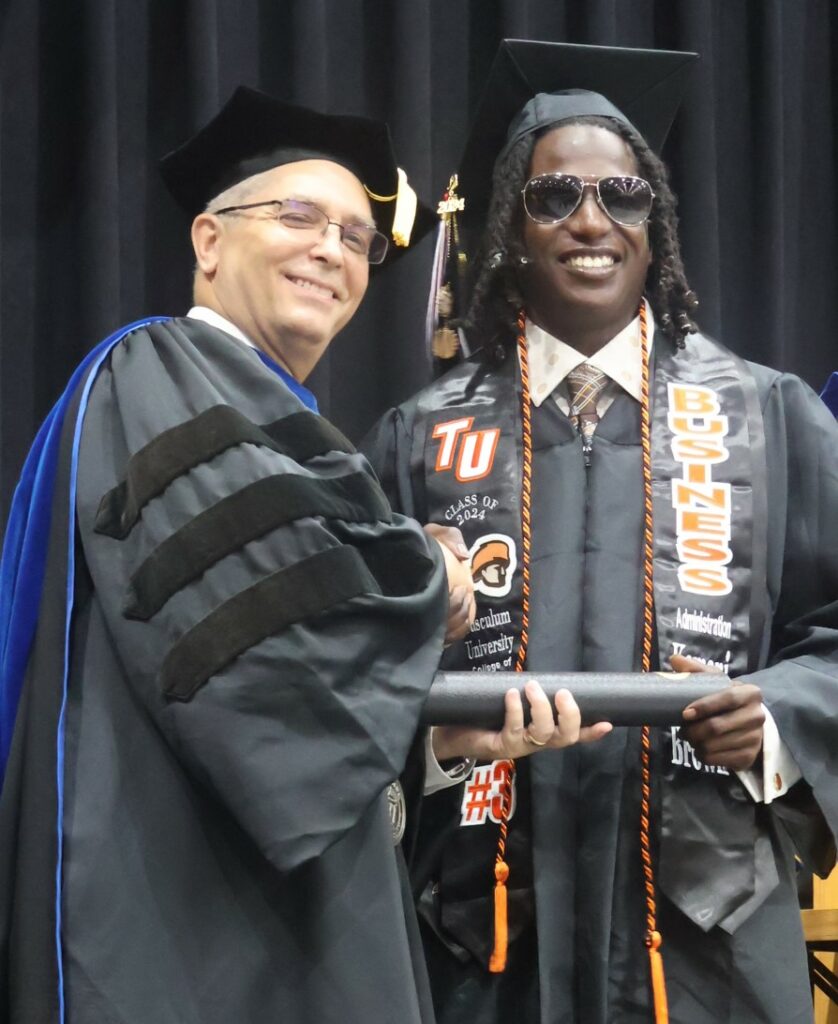 Dr. Hummel, left, congratulates a graduate.