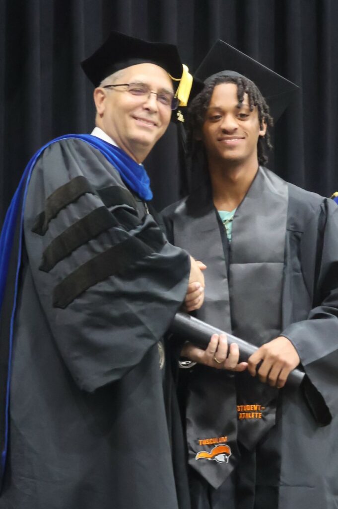 Dr. Hummel, left, congratulates a graduate.