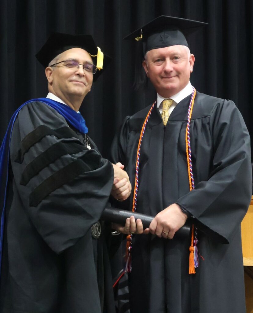 Dr. Hummel, left, congratulates a graduate.