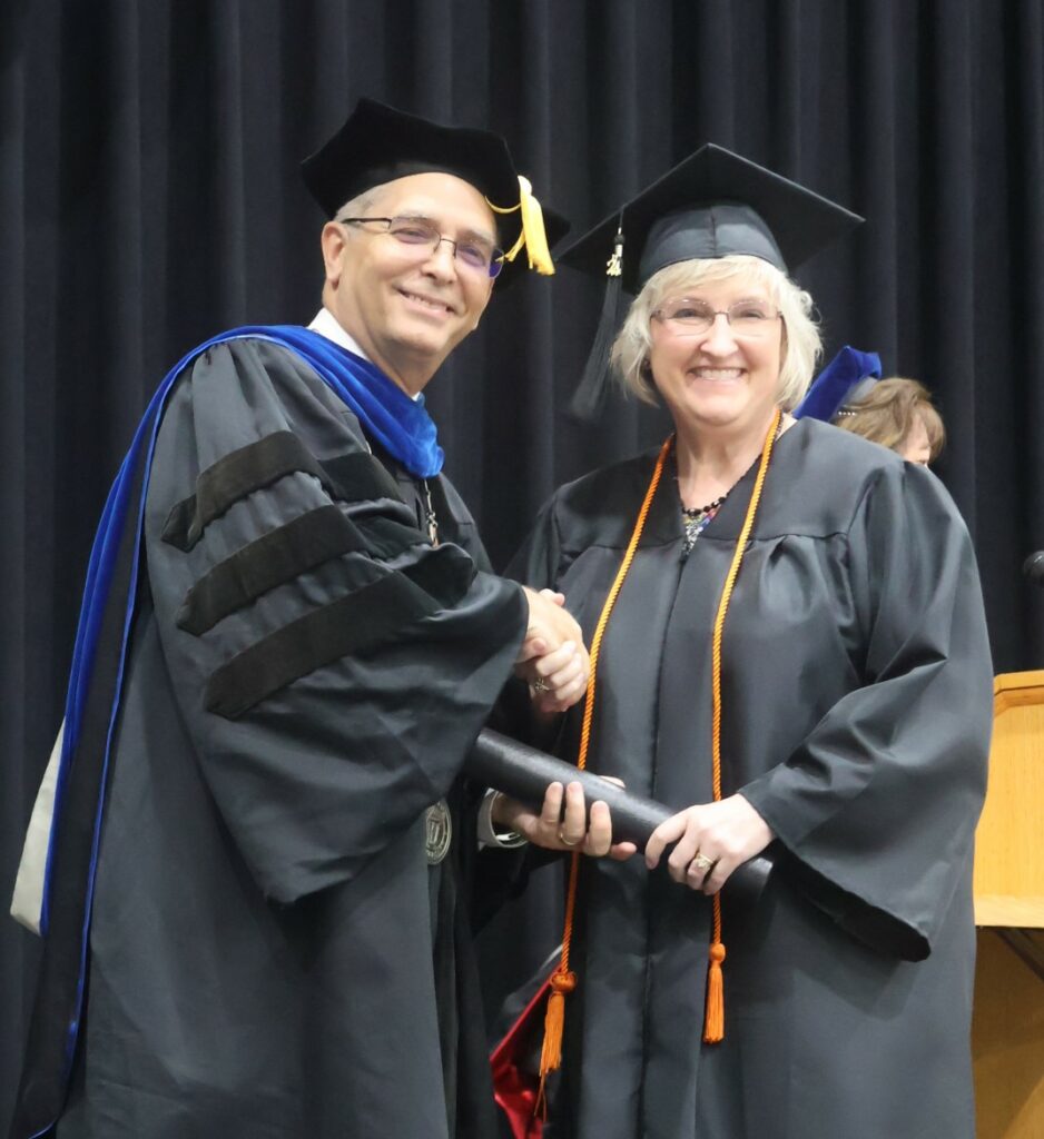Dr. Hummel, left, congratulates a graduate.