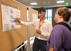Conor Fitzgerald, left, shows his poster to Raigun Duncan at the 2024 Summer Academy.