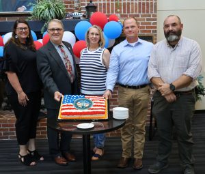 Tusculum University employees and community members pose with the cake for Charter Day. Left to right are Tiffany Greer, Tim Massey, Shannon Minnick, the Rev. E.J. Swatsell and Dr. Peter Noll.