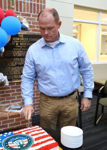 The Rev. E.J. Swatsell cuts the cake.
