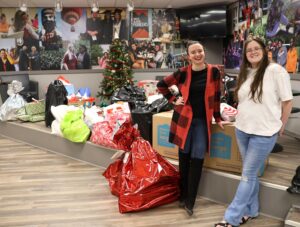 Dr. Shelby Ward, director of the Center for Civic Advancement, and Amanda Lunceford, a member of the Bonner Leader Program, stand by gifts for the Angel Tree initiative.
