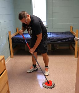 Mike Brisbin cleans the floor in one of the residence halls.