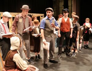 Tusculum student Todd Wallin, gesturing, participates in a rehearsal for “Newsies.”