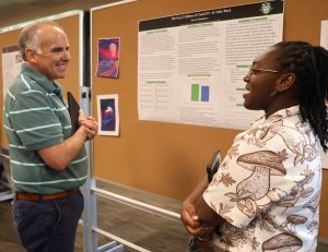 Dr. David Smith, left, speaks with student Shawny Humphreys about her poster at the Upward Bound and Upward Bound Math and Science Summer Academy in 2024.