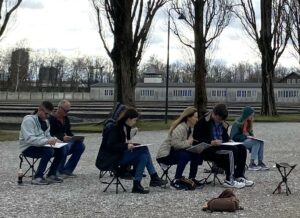 Participants in the trip draw en plein air at Dachau concentration camp.
