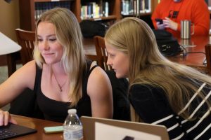 Maia Scott, right, reviews Hailey Silvestri’s paper with her.
