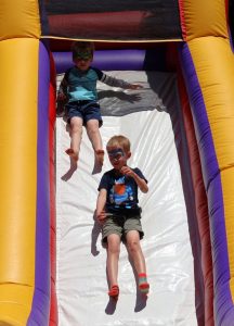 Children slide down an inflatable.