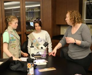Dr. Kate Smith, right, a Tusculum psychology professor, instructs two Girl Scouts.