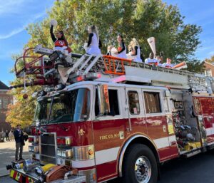 The Tusculum cheerleading team rides a fire truck during the Homecoming parade in 2022.