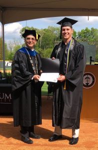 Student posing with Dr. Hummel holding their award