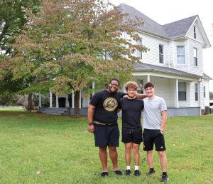 Left to right, T-Ray Threat, Elijah Ramos and Rio Little, who live in the Discipleship Living-Learning Center, stand in front the male house.