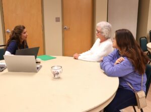 Lori Moore with Mountain Ways, left, speaks with recipients Sharon Mathes, middle, and Tina Kempa.