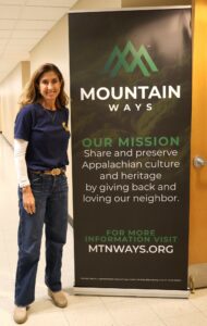 Lori Moore stands by a Mountain Ways banner.