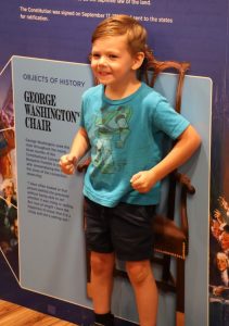 A boy sits in George Washington’s chair.