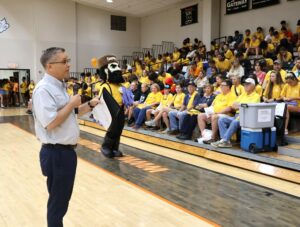 Dr. Scott Hummel speaks with students, faculty, staff and community members as Zeke, the university’s mascot stands by, at the start of Nettie Fowler McCormick Service Day.