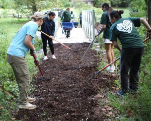 Tusculum family members spread mulch on the university’s nature trail.