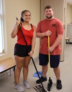 Maya White Eagle, left, and Chaz Waine clean at Notre Dame Catholic Church.