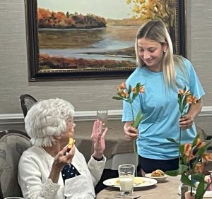 Student Abby Cruz presents a flower to a resident of Morning Pointe Senior Living of Greeneville.