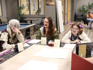 These three Tusculum students play Dungeons & Dragons at Pioneer CON in 2024. They are, left to right, Isabella Gall, Haylee Miller and Emme Foster.