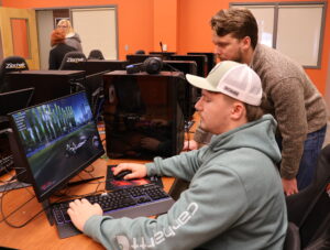 Dr. Nick Davidson, right, watches Joseph Cole play a game of Rocket League.