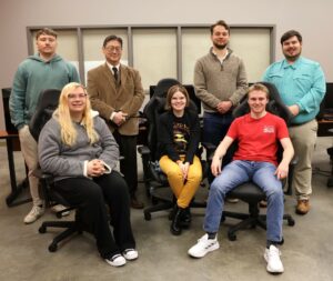 Some members of the gaming and esports clubs and their coaches take a break from planning to encourage people to attend Pioneer Con. Left to right are Joseph Cole, Adriann Aldridge, Dr. Harold Branstrator, Emme Foster, Dr. Nick Davidson, Joseph Medeck and Hughston Burnheimer. They are in the esports and gaming lab on the fourth floor of the Scott M. Niswonger Commons.