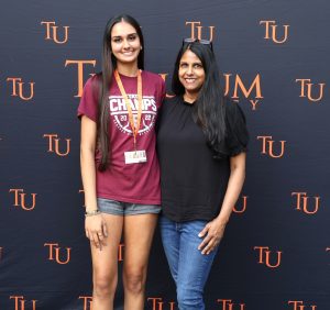 Incoming student Aisha Patel, left, poses for a photo with a family member during Pioneer Quest.