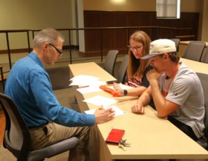 Dr. Kevin Hill, left, associate professor of management, speaks with a new student.