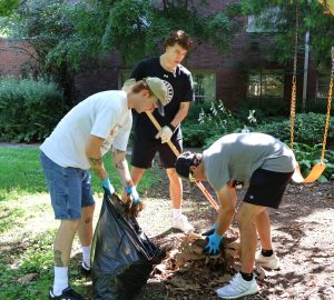 Three new students perform service work during Freshman Day of Service.