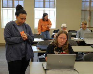 Erin Goins, left, and Kassidy Babler, second from left, work on résumés with students.