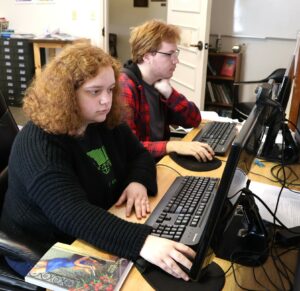 Tusculum students Zoey Seay, left, and Zach Mitchell are two of the students who have collaborated on The Tusculum Review. She is working on the journal’s back cover.