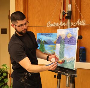 Benjamin Conley teaches participants at Valentine’s Painting Night in 2025.