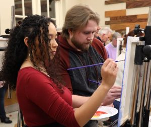 Mattie Olmsted, left and Trevor Kahland work on their painting at the 2025 event.