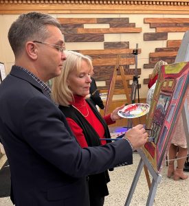 Dr. Scott Hummel, left, and his wife Starr apply the paint strokes at the inaugural painting event. 